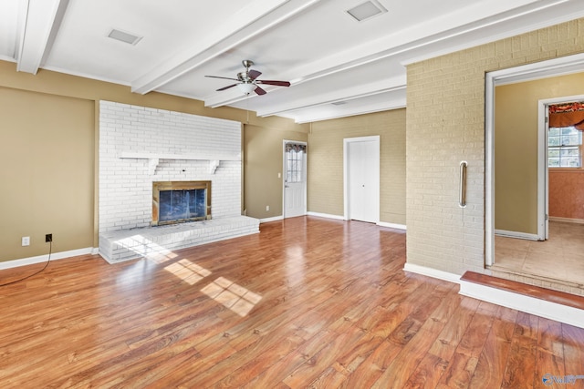 unfurnished living room featuring a fireplace, hardwood / wood-style flooring, beamed ceiling, and ceiling fan