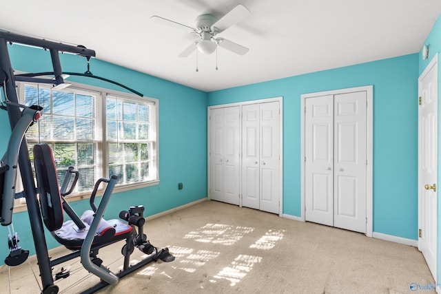 exercise area with ceiling fan and light colored carpet