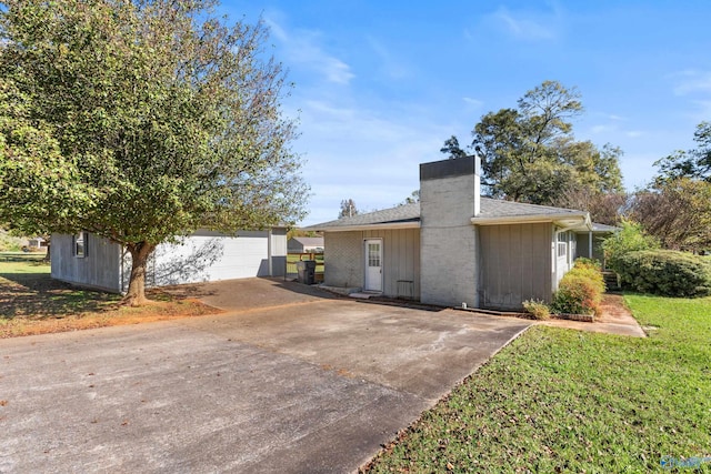 view of front of home featuring an outbuilding, a garage, and a front lawn