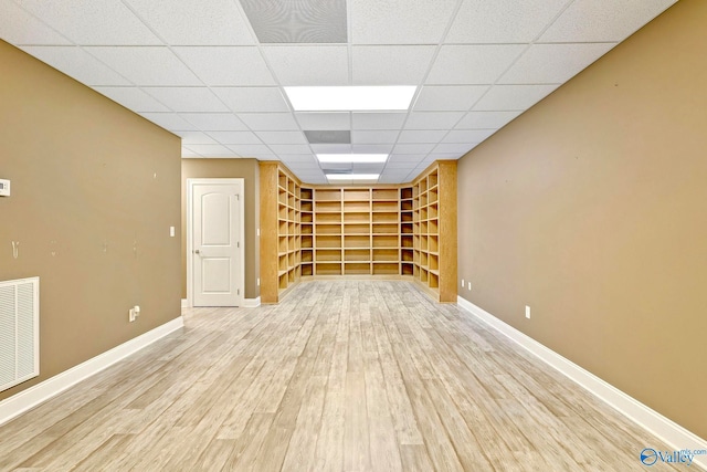 unfurnished room featuring a paneled ceiling and light wood-type flooring