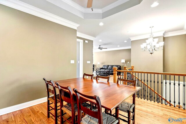 dining room with light hardwood / wood-style floors, ornamental molding, and ceiling fan with notable chandelier