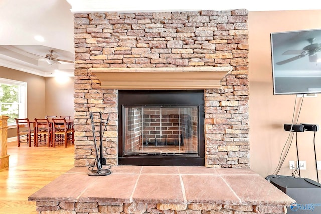 details with crown molding, hardwood / wood-style flooring, a fireplace, and ceiling fan