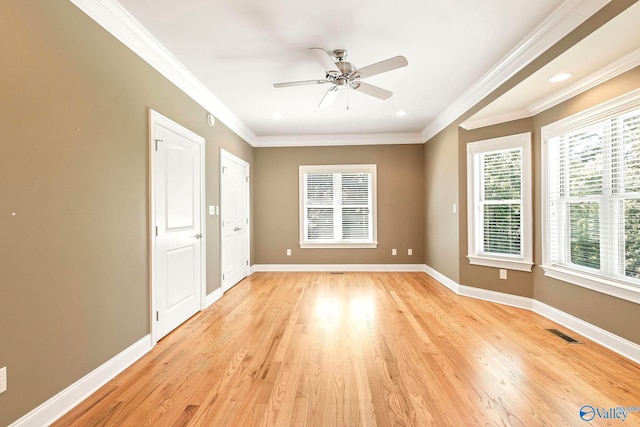 spare room featuring crown molding, light wood-type flooring, and ceiling fan