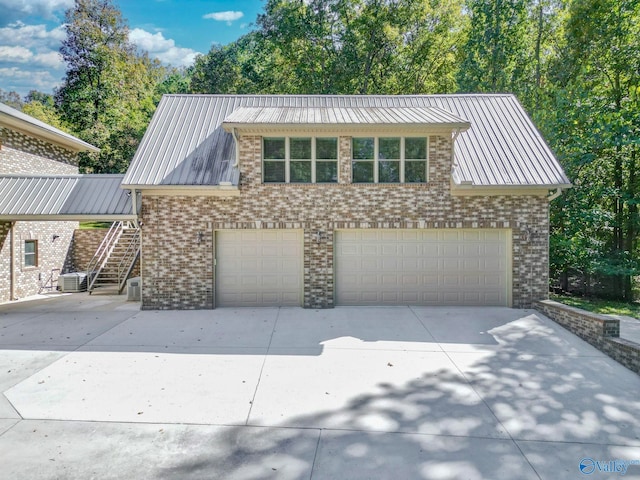 view of front of house with cooling unit and a garage