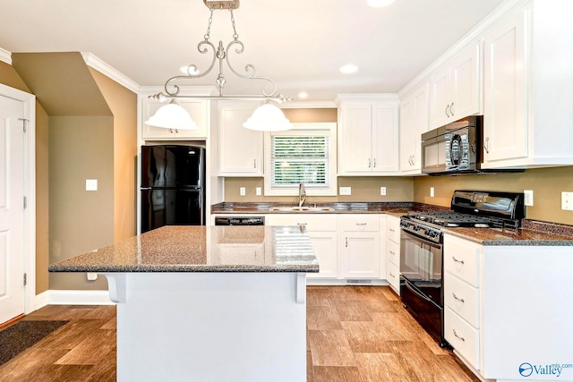 kitchen featuring white cabinetry, black appliances, a center island, and hanging light fixtures