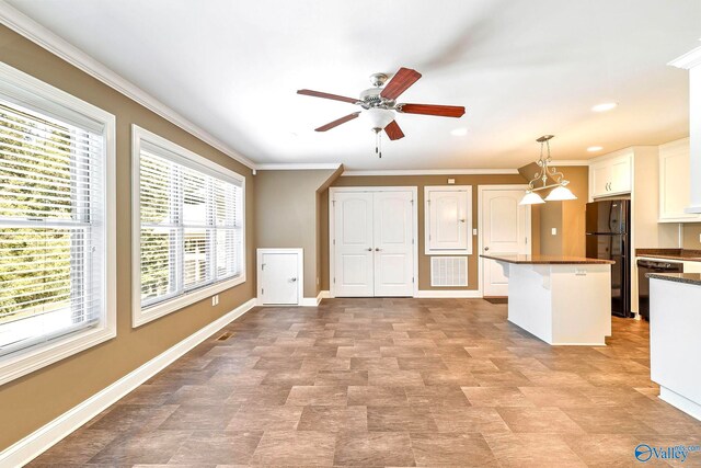 kitchen featuring white cabinets, a healthy amount of sunlight, black appliances, and hanging light fixtures