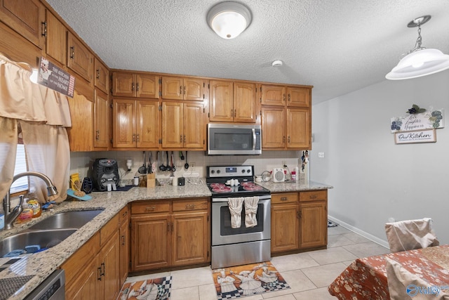 kitchen featuring sink, decorative light fixtures, stainless steel appliances, and light tile patterned flooring