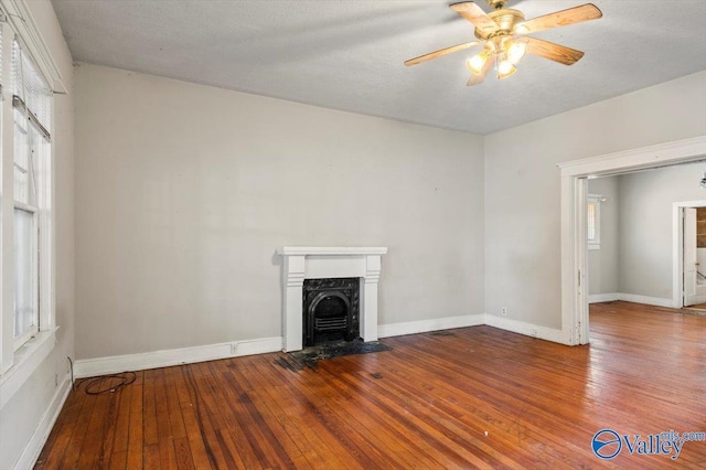 unfurnished living room with hardwood / wood-style flooring, a textured ceiling, and ceiling fan