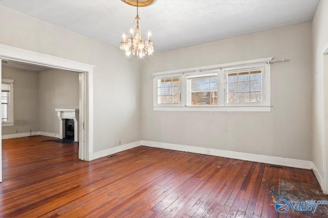 unfurnished dining area with an inviting chandelier and dark hardwood / wood-style flooring