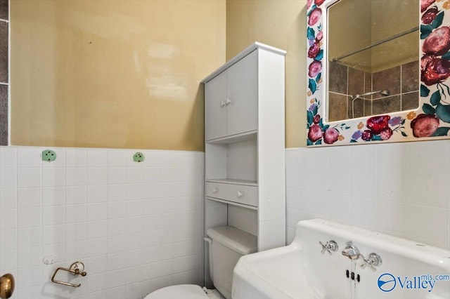 bathroom featuring tile walls and toilet