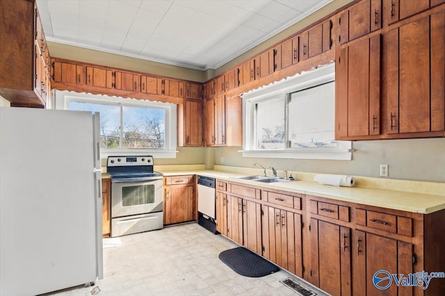 kitchen featuring ornamental molding, sink, and white appliances