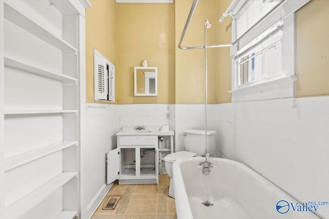 bathroom with a washtub, tile walls, and toilet