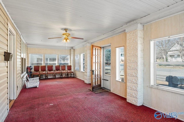 unfurnished sunroom featuring ceiling fan