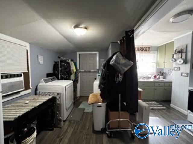 clothes washing area with independent washer and dryer, hardwood / wood-style flooring, and cooling unit