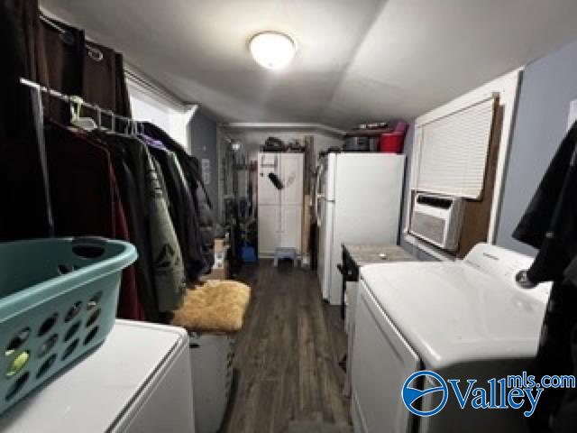 laundry area with cooling unit, washer and dryer, and dark hardwood / wood-style floors