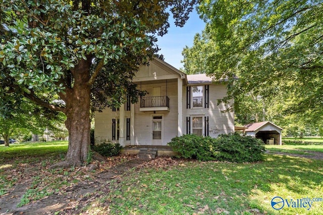 view of front of home featuring a front yard and a balcony