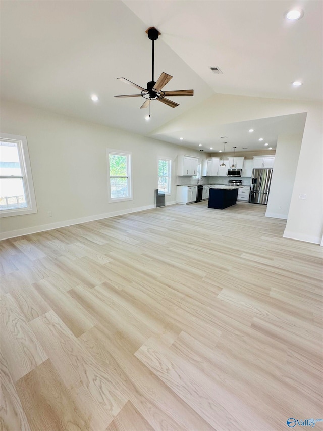 unfurnished living room featuring light hardwood / wood-style floors, ceiling fan, and vaulted ceiling