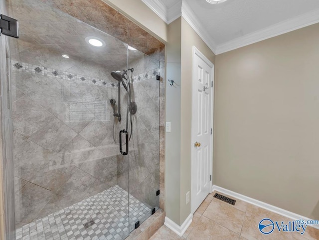 bathroom featuring tile patterned floors, ornamental molding, baseboards, visible vents, and a stall shower