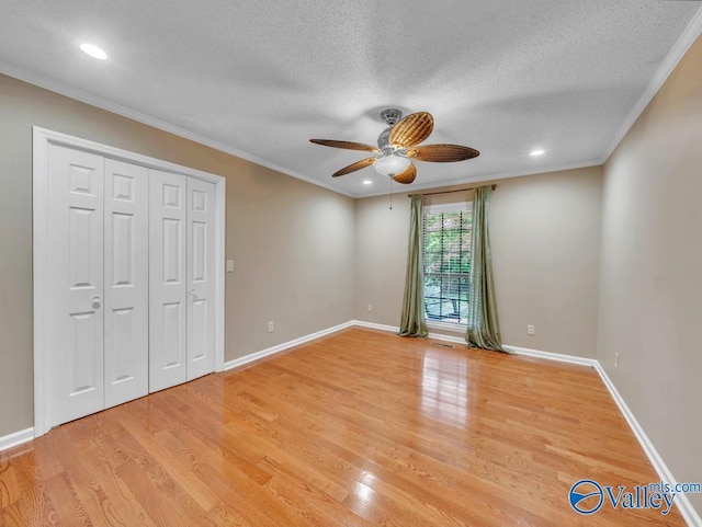 unfurnished bedroom featuring baseboards, ornamental molding, and light wood-style flooring