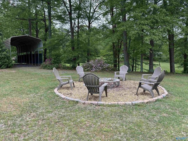 view of yard with a fire pit and a carport
