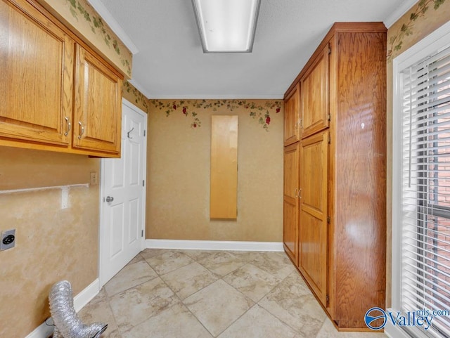 washroom featuring electric dryer hookup, crown molding, cabinet space, and baseboards