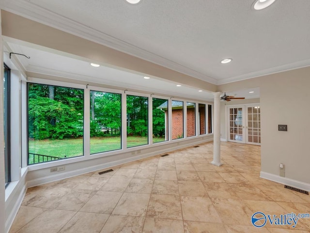 spare room featuring baseboards, ornamental molding, a ceiling fan, and plenty of natural light
