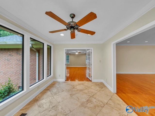 spare room featuring a healthy amount of sunlight, ceiling fan, and crown molding