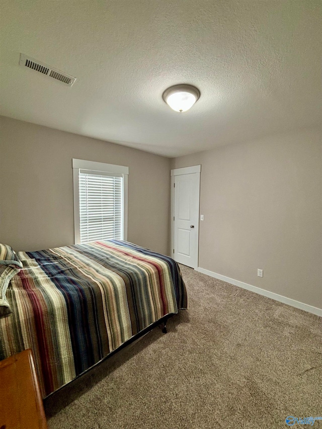 carpeted bedroom featuring a textured ceiling