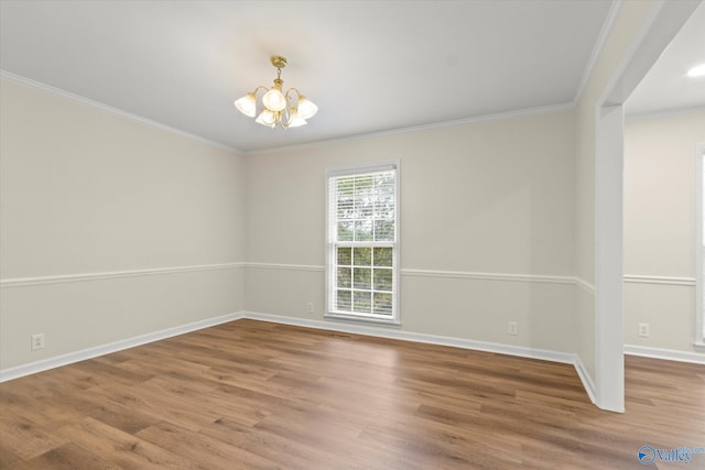 unfurnished room with ornamental molding, a notable chandelier, and wood-type flooring