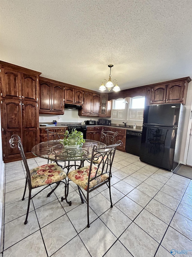 kitchen with dark brown cabinets, black appliances, light tile patterned floors, decorative light fixtures, and an inviting chandelier