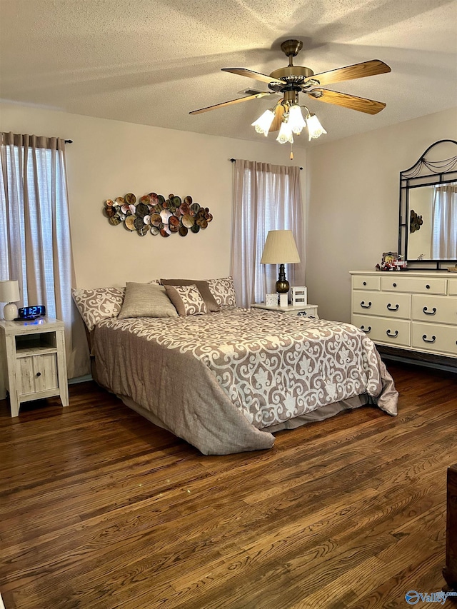 bedroom featuring ceiling fan, dark hardwood / wood-style flooring, and a textured ceiling