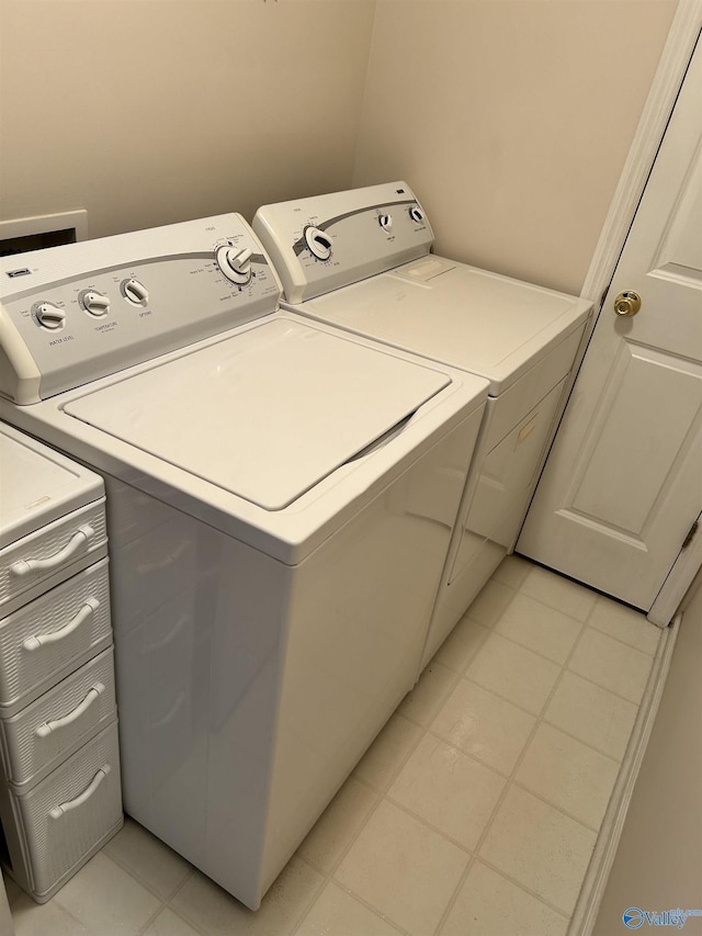 washroom with light tile patterned floors and washer and dryer