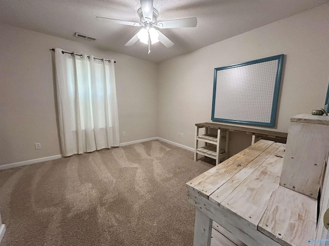 carpeted spare room with ceiling fan and a textured ceiling