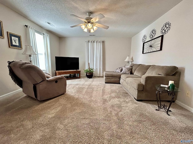 living room with a textured ceiling, light colored carpet, and ceiling fan