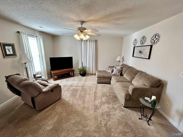 living room featuring ceiling fan, carpet floors, and a textured ceiling