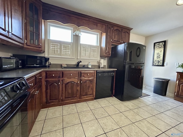 kitchen with black appliances, dark brown cabinets, light tile patterned floors, and sink