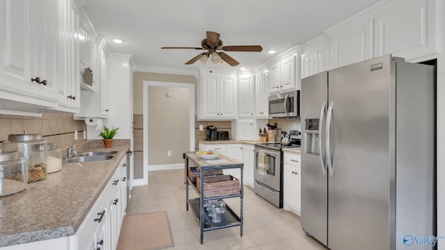 24147 Jacobs Dr, Athens, AL 35613 - kitchen with stainless steel appliances, a sink, a ceiling fan, white cabinets, and light tile patterned floors