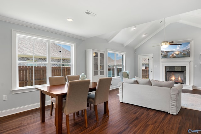 dining space featuring dark wood-type flooring, baseboards, a fireplace, and vaulted ceiling with beams