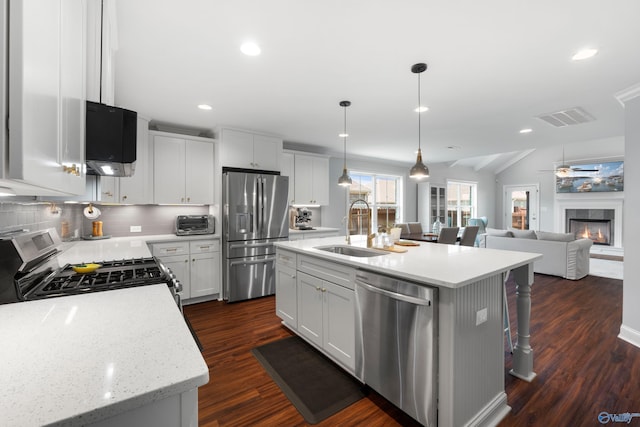 kitchen with backsplash, dark wood-style flooring, visible vents, a sink, and stainless steel appliances