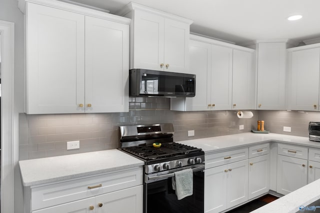 kitchen with light stone counters, decorative backsplash, white cabinetry, and stainless steel gas range