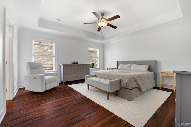 bedroom featuring crown molding, a raised ceiling, ceiling fan, and dark wood-style floors