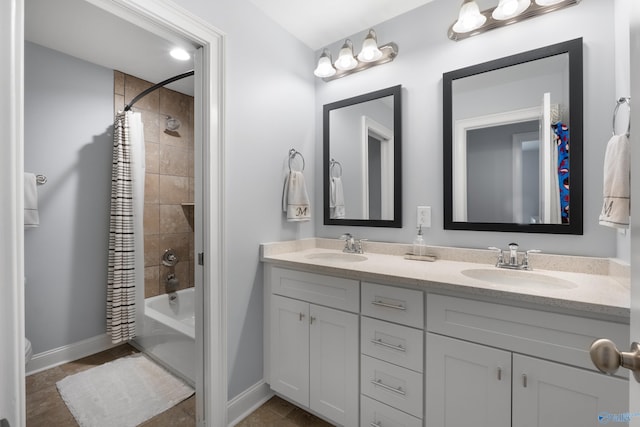 full bath with double vanity, a sink, baseboards, and shower / tub combo