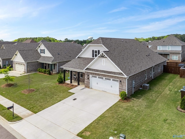 craftsman-style house with a front yard, a residential view, a garage, fence, and concrete driveway