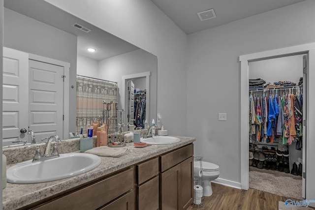 bathroom with vanity, hardwood / wood-style flooring, toilet, and walk in shower