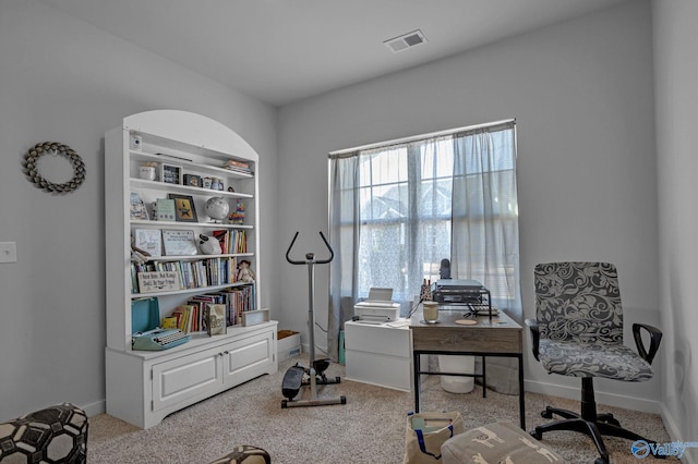 office space with built in shelves and light carpet