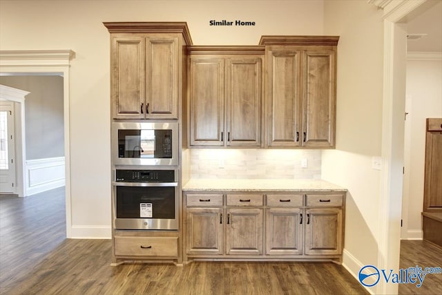 kitchen featuring backsplash, light stone counters, stainless steel appliances, and dark wood-style floors
