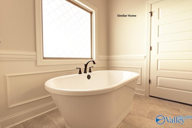 full bathroom with tile patterned flooring and a freestanding bath