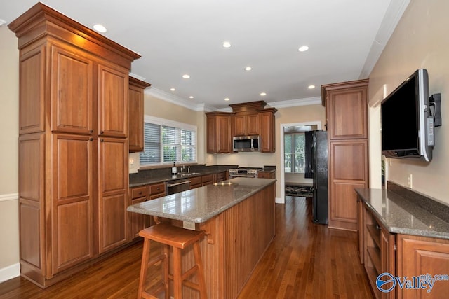 412 Clydebank Dr, Madison, AL 35758 - kitchen with appliances with stainless steel finishes, dark wood-type flooring, a center island, crown molding, and brown cabinetry
