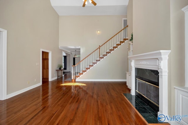 412 Clydebank Dr, Madison, AL 35758 - unfurnished living room featuring stairs, wood finished floors, ceiling fan, baseboards, and a towering ceiling