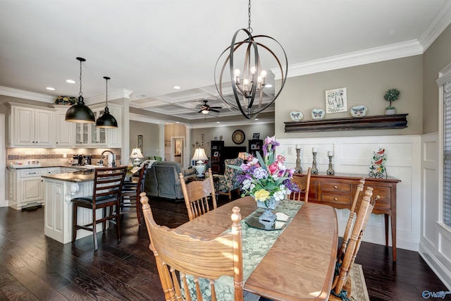 dining area featuring dark wood-type flooring, beam ceiling, crown molding, ceiling fan with notable chandelier, and coffered ceiling